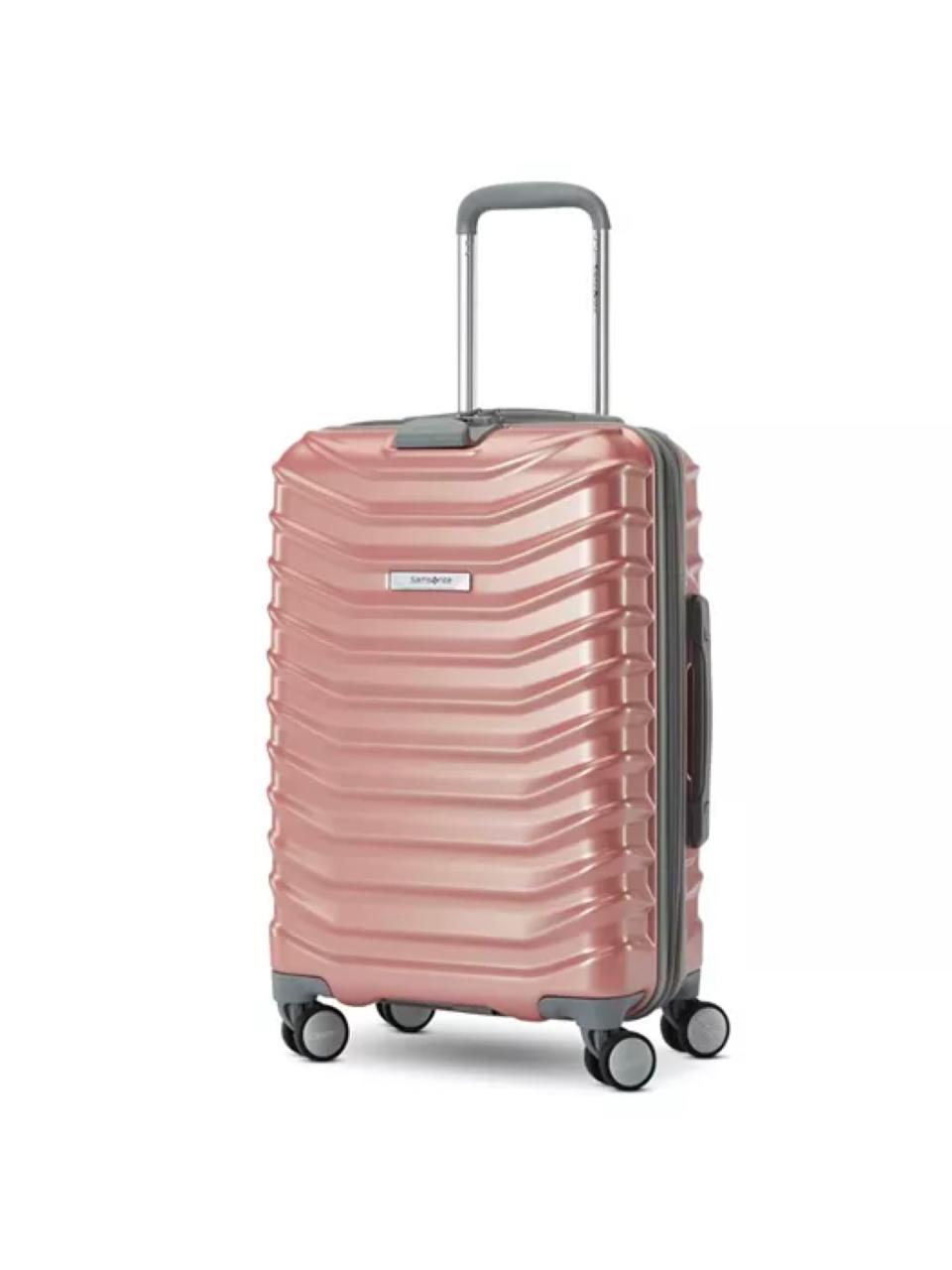 A pink and silver small carry-on spinner suitcase