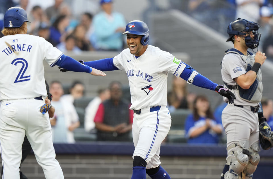 Toronto Blue Jays' George Springer, center, celebrates his three-run home run against the New York Yankees with Justin Turner (2) during the first inning of a baseball game in Toronto on Thursday, June 27, 2024. (Frank Gunn/The Canadian Press via AP)