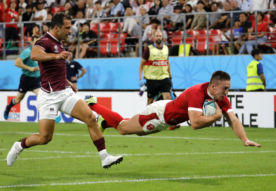 Wales Josh Adams dives across the line to score his side's third try during the Rugby World Cup Pool D game between Wales and Georgia at Toyota City Stadium, Toyota City, Japan, Monday, Sept. 23, 2019. (AP Photo/Christophe Ena)