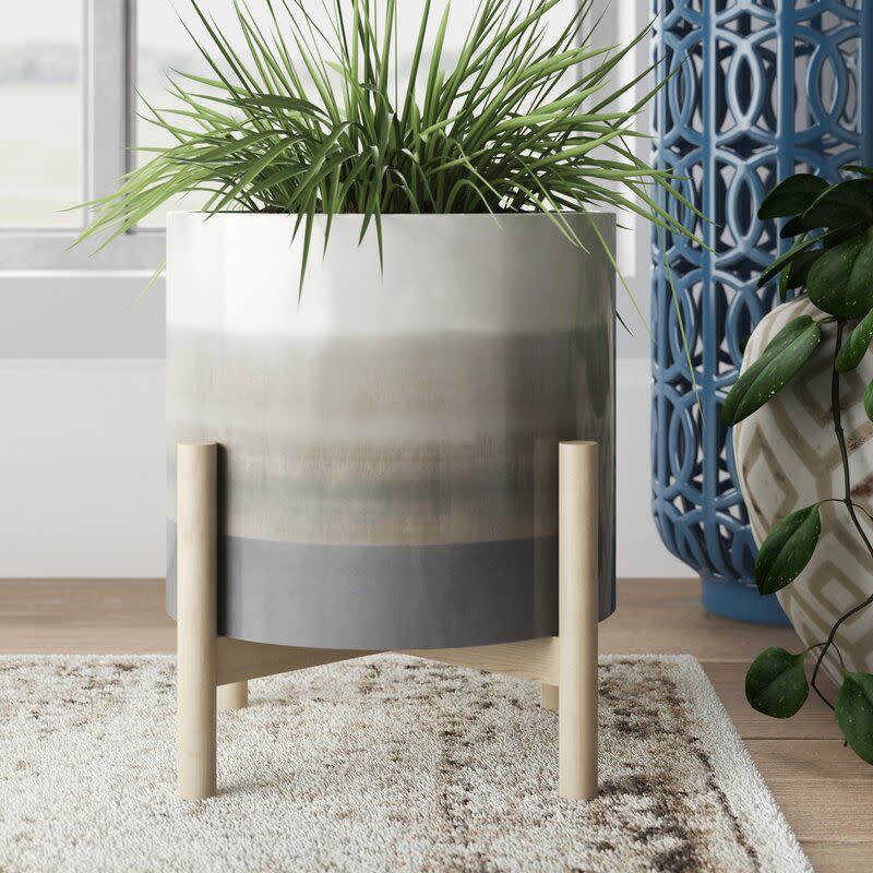 <p><a href="https://go.redirectingat.com?id=74968X1596630&url=https%3A%2F%2Fwww.wayfair.com%2F--%2Fpdp%2Febern-designs--planter-on-stand-ceramic-planter-on-wooden-stand-contemporary-ivorybeige-gradient-design-indoor-or-outdoor-plant-stand-decor-x115689441-l349-w004578330.html&sref=https%3A%2F%2F" rel="nofollow noopener" target="_blank" data-ylk="slk:Shop Now;elm:context_link;itc:0;sec:content-canvas" class="link ">Shop Now</a></p><p>Ceramic Indoor/Outdoor Planter on Wooden Stand </p><p>wayfair.com</p><p>$30.99</p>