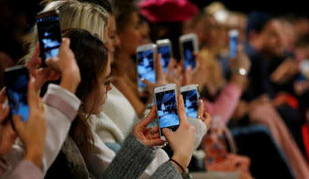 FILE PHOTO: A so-called media influencer takes pictures at Berlin Fashion Week, January 19, 2017. REUTERS/Hannibal Hanschke/File Photo