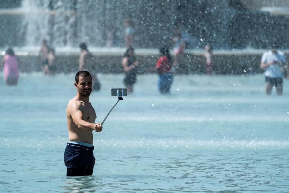 A man takes a selfie picture with a mobile-phone as he stands in the middle of the Trocadero fountain in Paris. (AFP/Getty Images)
