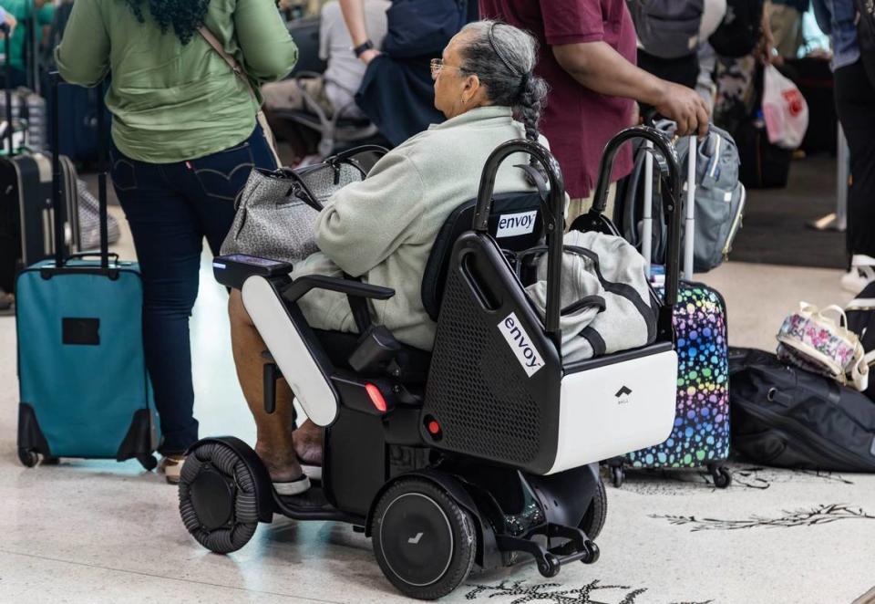 Una clienta de American Airlines montada en una silla de ruedas autónoma WHILL antes de su vuelo en el Pasillo D del Aeropuerto Internacional de Miami (MIA) el viernes 21 de junio de 2024 en Miami, la Florida.