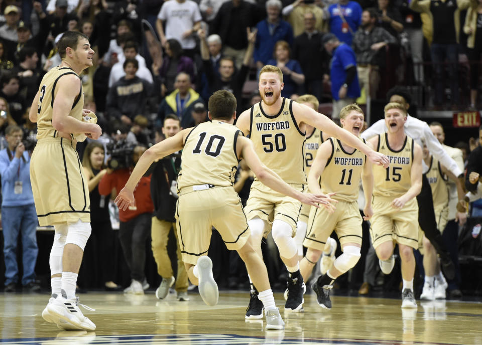 Wofford guard Fletcher Magee (3), guard Nathan Hoover (10), center Matthew Pegram (50), guard Ryan Larson (11) and guard Trevor Stumpe (15) celebrates their team's 70-58 win over UNC-Greensboro for the Southern Conference tournament championship, Monday, March 11, 2019, in Asheville, N.C.  (AP Photo/Kathy Kmonicek)