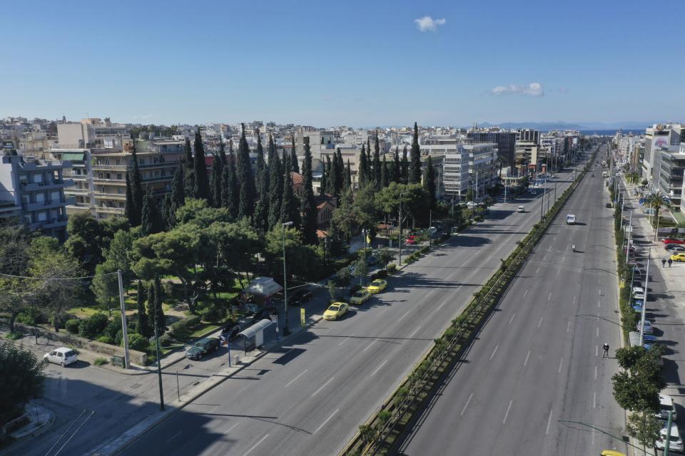 In this Thursday, April 2, 2020 photo, cars use Syngrou avenue, a major road linking the central Athens with the southern seaside zone of the Greek capital. Deserted squares, padlocked parks, empty avenues where cars were once jammed bumper-to-bumper in heavy traffic. The Greek capital, like so many cities across the world, has seen its streets empty as part of a lockdown designed to stem the spread of the new coronavirus. (AP Photo/Thanassis Stavrakis)