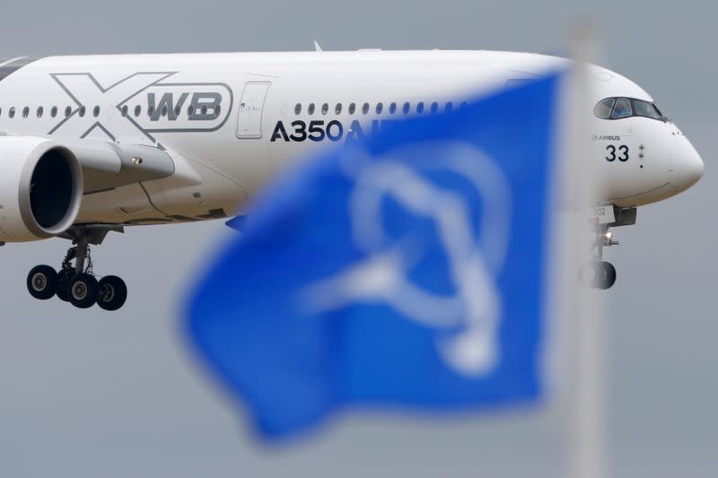 FILE PHOTO: An Airbus A350 flies over a Boeing flag while landing after a flying display during the 51st Paris Air Show at Le Bourget airport near Paris