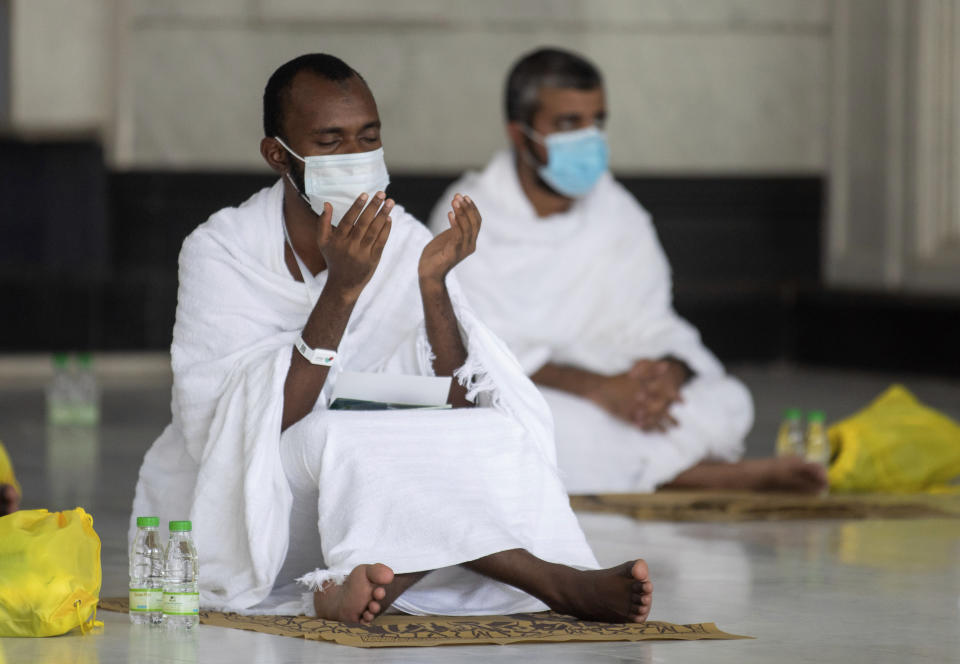 In this photo released by the Saudi Media Ministry, a limited numbers of pilgrims pray in the first rituals of the hajj, as they keep social distancing to limit exposure and the potential transmission of the coronavirus, at the Grand Mosque in the Muslim holy city of Mecca, Saudi Arabia, Wednesday, July 29, 2020. A unique and scaled-down hajj started on Wednesday. (Saudi Media Ministry via AP)