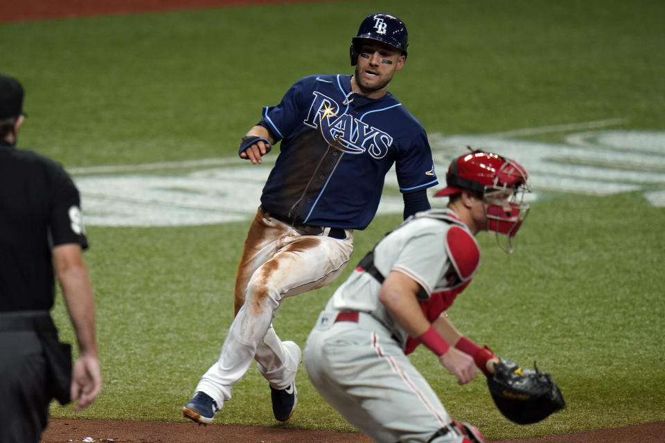 Tampa Bay Rays' Kevin Kiermaier scores behind Philadelphia Phillies catcher Andrew Knapp on an RBI single by Brett Phillips off pitcher Vince Velasquez during the second inning of a baseball game Friday, Sept. 25, 2020, in St. Petersburg, Fla. (AP Photo/Chris O'Meara)