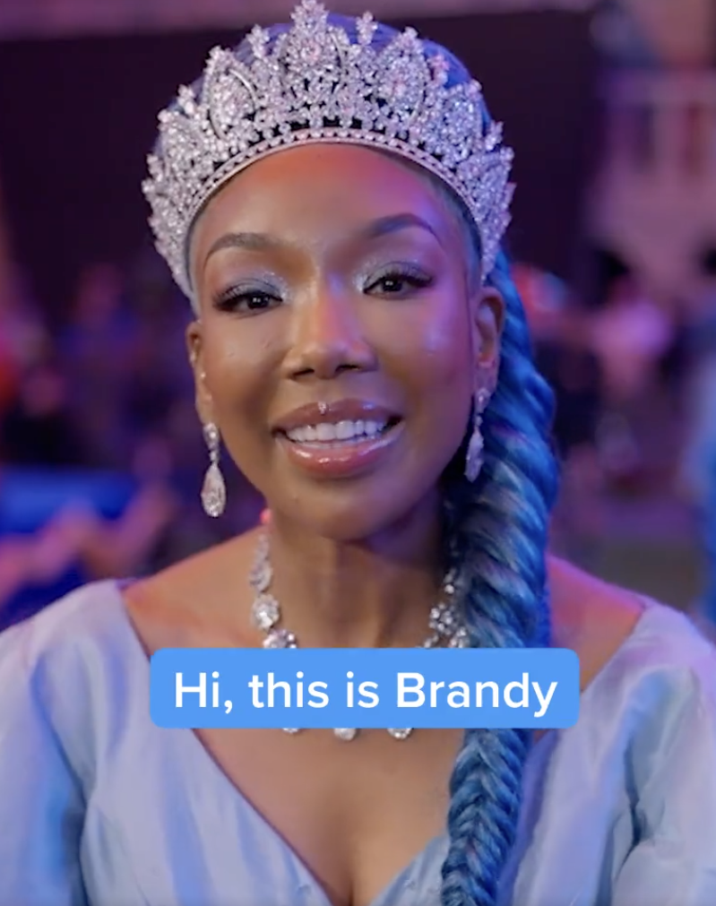 Brandy dressed as Cinderella. She's wearing an ornate tiara and a long blue braid