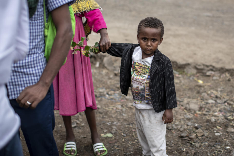 A young boy carries flowers as Ethiopian Orthodox Christians celebrate Easter Sunday in Gondar, in the Amhara region of Ethiopia Sunday, May 2, 2021. Ethiopia faces a growing crisis of ethnic nationalism that some fear could tear Africa's second most populous country apart, six months after the government launched a military operation in the Tigray region to capture its fugitive leaders. (AP Photo/Ben Curtis)