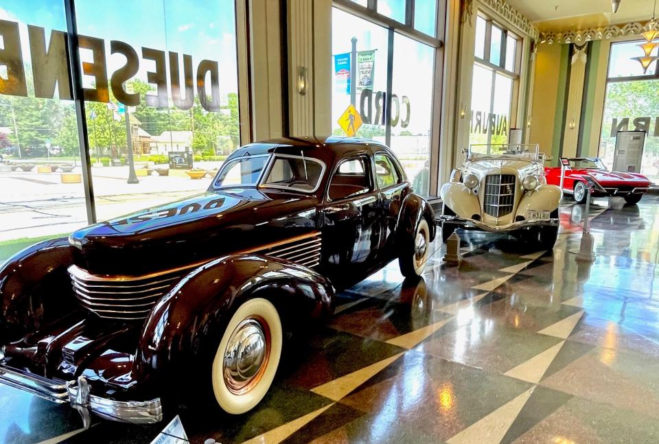 Classic vehicles are lined up along the showroom window at the Auburn museum.