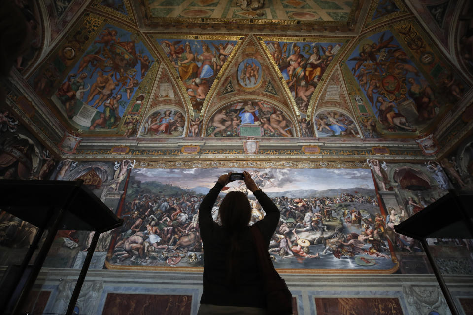 A visitor admires a Raphael Room inside the Vatican Museums on their reopening, in Rome, Monday, May 3, 2021. The Vatican Museums reopened Monday to visitors after a shutdown following COVID-19 containment measures. (AP Photo/Alessandra Tarantino)