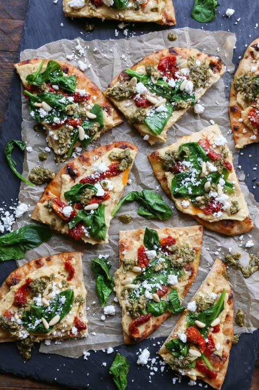 <p>The Roasted Root</p><p>Hummus flatbread with sun-dried tomatoes, feta, spinach, pine nuts, and pesto sauce makes for an easy-to-prepare appetizer or snack.</p><p><strong>Get the recipe:</strong> <a href="https://www.theroastedroot.net/hummus-flatbread-sun-dried-tomato-spinach-pesto/" rel="nofollow noopener" target="_blank" data-ylk="slk:Hummus Flatbread with Sun-Dried Tomato Spinach Pesto;elm:context_link;itc:0;sec:content-canvas" class="link rapid-noclick-resp"><strong>Hummus Flatbread with Sun-Dried Tomato Spinach Pesto</strong></a></p>