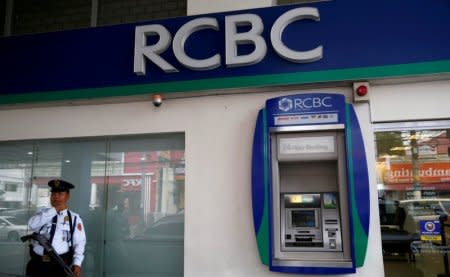 FILE PHOTO: A security guard stands guard outside a branch of Rizal Commercial Banking Corporation (RCBC) in Paranaque city, Metro Manila, Philippines August 2, 2016. REUTERS/Erik De Castro/File Photo