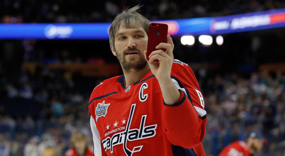 Even Alexander Ovechkin is checking out the Yahoo Fantasy app on his phone, probably. (Photo by Mike Carlson/Getty Images)