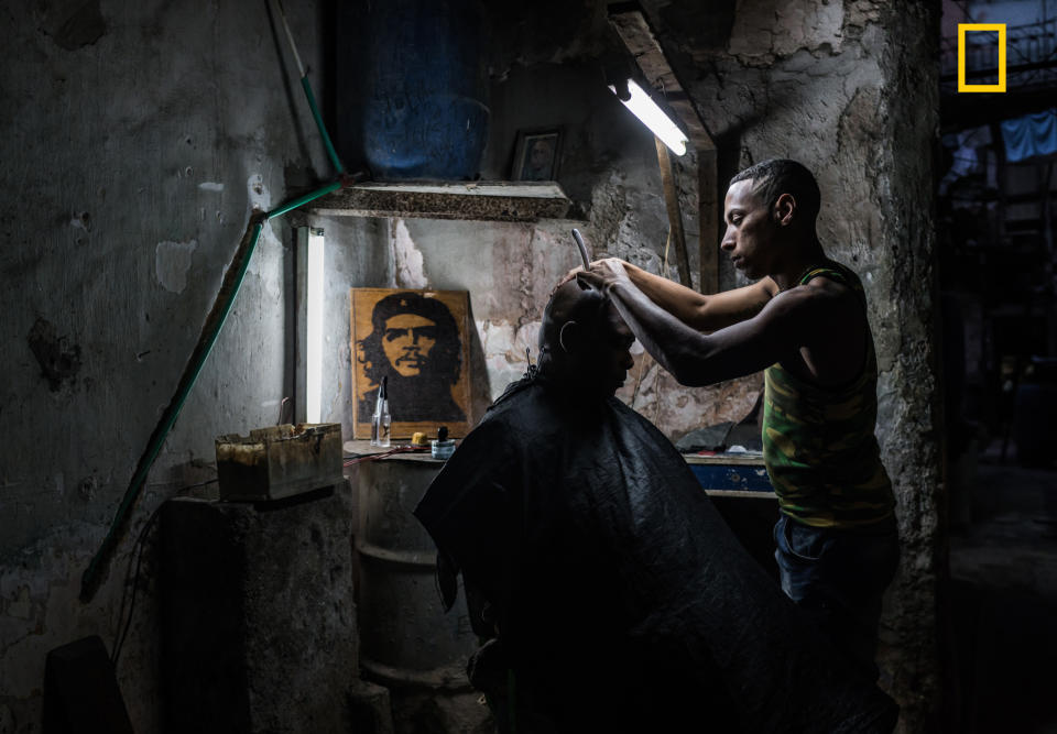 <p>“This Cuban barber has a shop in the run down building he lives in. He has managed to hook up water and electricity and has a steady flow of clients. I couldn’t get enough of the atmosphere and visited the shop several times and each time was welcomed in with a smile.” (© Kelly Beckta/National Geographic Travel Photographer of the Year Contest </p>