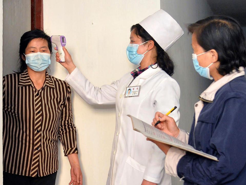 In this photo provided by the North Korean government, a doctor checks a resident's temperature to curb the spread of coronavirus infection, in Pyongyang, North Korea on May 17, 2022.