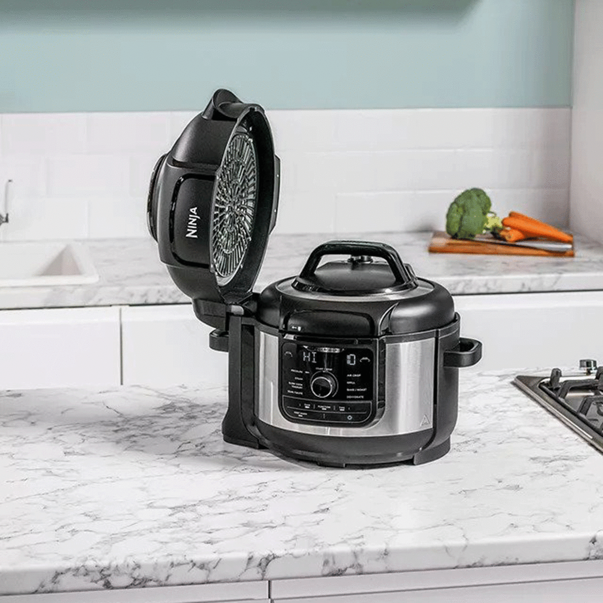  Black Russell Hobbs multi cooker next to food on white kitchen worktop. 