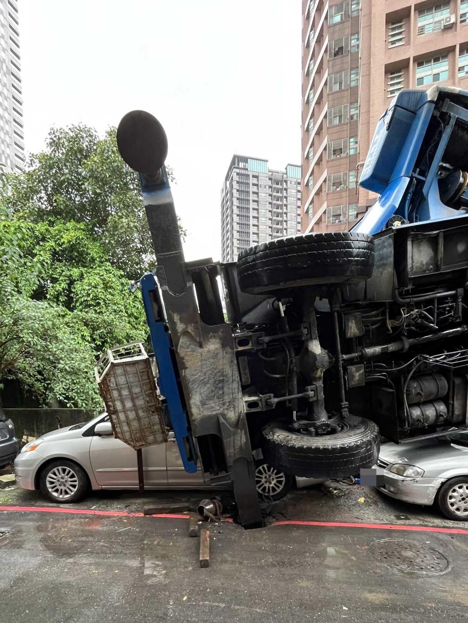 工程車翻覆壓到轎車。（圖／東森新聞）