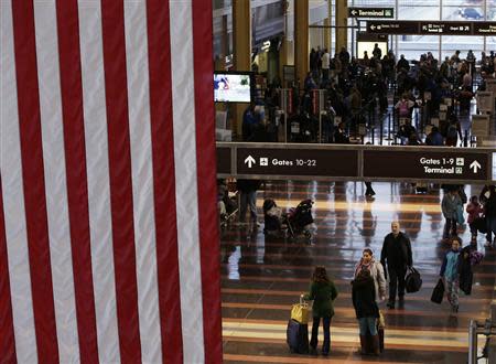 Thanksgiving Eve travelers walk down the Reagan National Airport main concourse in Washington November 27, 2013. REUTERS/Gary Cameron