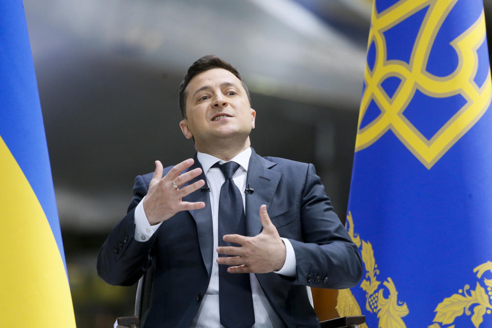 Ukrainian President Volodymyr Zelenskyy gestures while speaking to the media during a news conference with the world's largest airplane, Ukrainian Antonov An-225 Mriya in the background at the Antonov aircraft factory in Kyiv, Ukraine, Thursday, May 20, 2021. (AP Photo/Efrem Lukatsky)