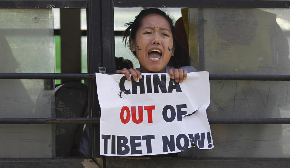 FILE - In this Tuesday, March 10, 2015, file photo, a Tibetan exile shouts slogans against China after being detained inside a police bus during a protest in New Delhi, India. China says it will not "renounce the use of force" in efforts to reunify Taiwan with the mainland and vows to take all necessary military measures to defeat "separatists." (AP Photo/Altaf Qadri, File)