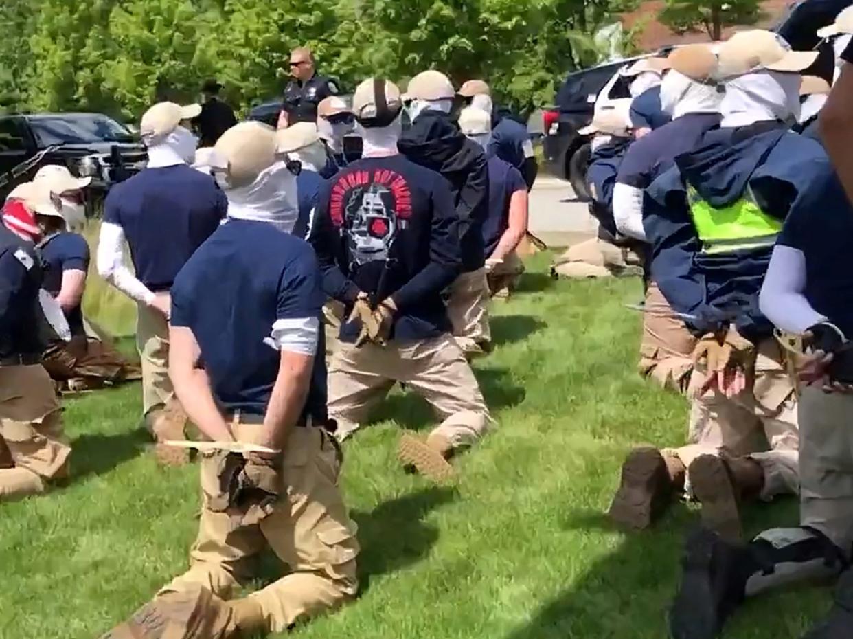 Police officers guard a group of men, who police say are among 31 arrested for conspiracy to riot and are affiliated with the white nationalist group Patriot Front, after they were found in the rear of a U Haul van in the vicinity of a North Idaho Pride Alliance LGBTQ+ event in Coeur d'Alene, Idaho, U.S. June 11, 2022 in this still image obtained from a social media video.