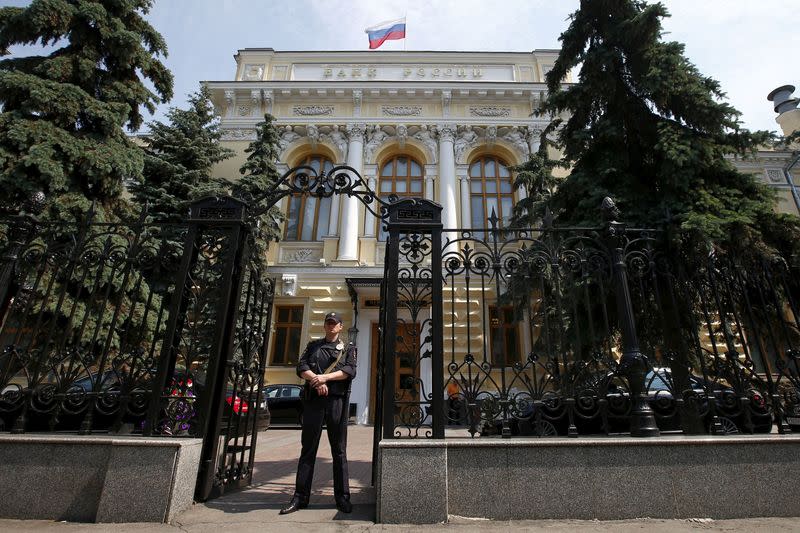 FILE PHOTO: Policeman stands guard at main entrance to Bank of Russia in Moscow