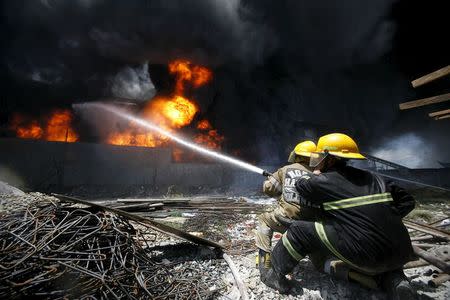 Firefighters attempt to control a raging fire at a factory that manufactures slippers in Valenzuela City, north of Manila May 13, 2015. REUTERS/Al Falcon