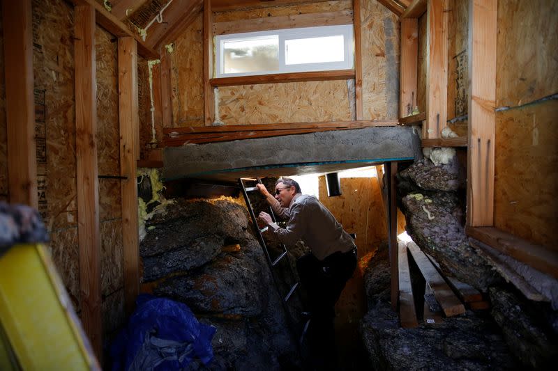 Drew Miller climbs up the ladder of a lookout perch at a survival camp