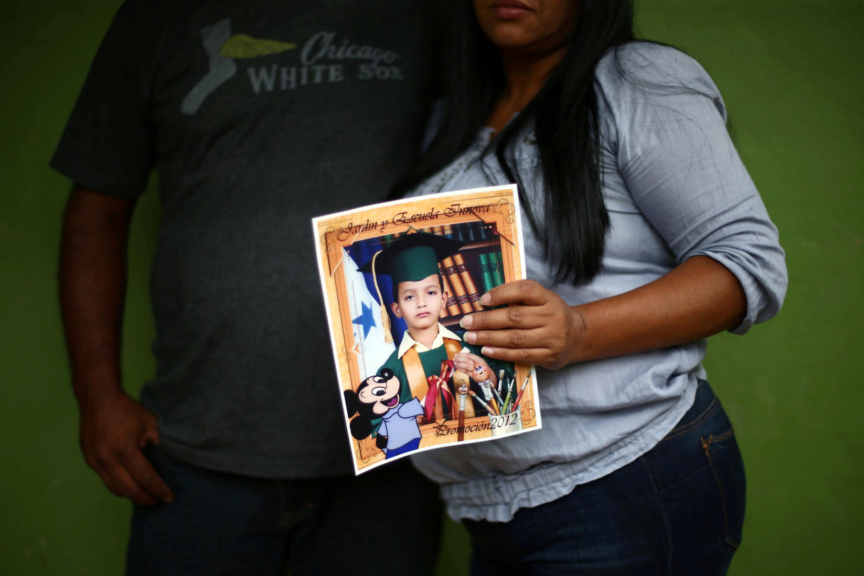 Douglas Almendarez and Evelin Meyer hold a picture of their son, Eduardo Almendarez. 