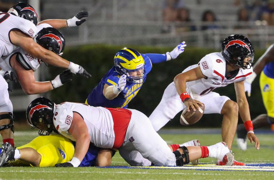 Delaware defensive lineman Jack Hall completes a sack on a restrained Saint Francis quarterback Nick Whitfield Jr. in the fourth quarter of the Blue Hens' 42-14 win at Delaware Stadium, Saturday Sept. 16, 2023. Whitfield was stripped of the ball but the Red Flash recovered.