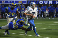 Detroit Lions quarterback Jared Goff gets away from Los Angeles Rams linebacker Terrell Lewis, below, during the second half of an NFL football game against the Los Angeles Rams Sunday, Oct. 24, 2021, in Inglewood, Calif. (AP Photo/Kevork Djansezian)