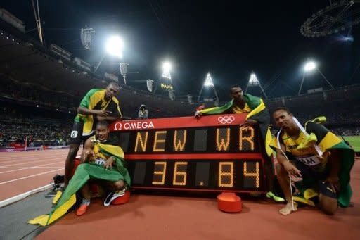 From L: Jamaica's Usain Bolt, Yohan Blake, Nesta Carter, Michael Frater pose by the record board after setting a new world record in the men's 4X100m relay final at the athletics event of the London 2012 Olympic Games