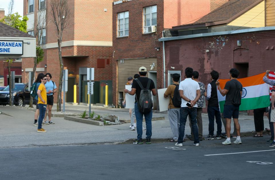 Purdue University students stop to read the signs being held in protest against the owner of the Blue Nile Restaurant over alleged racist comments he made about Indians, on May 5, 2023, in West Lafayette, Ind.