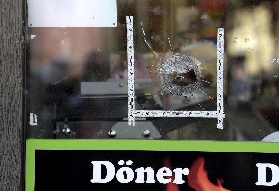 A bullet hole is seen in a window of a kebab grill in Halle, Germany, Thursday, Oct. 10, 2019. A heavily armed assailant ranting about Jews tried to force his way into a synagogue in Germany on Yom Kippur, Judaism's holiest day, then shot two people to death nearby in an attack Wednesday that was livestreamed on a popular gaming site. (AP Photo/Jens Meyer)