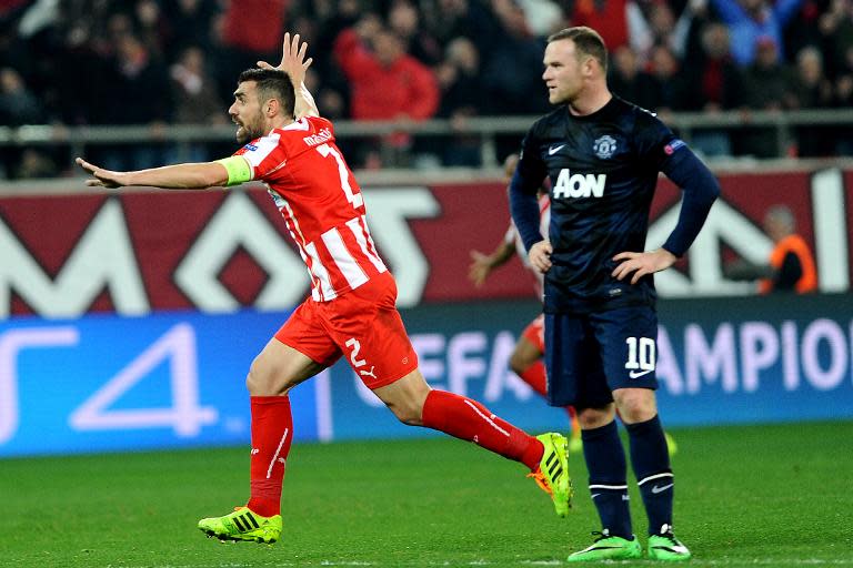 Olympiakos's Giannis Maniatis (L) celebrates scoring a goal during their UEFA Champions League round of 16 first leg match against Manchester United, at Karaiskaki Stadium in Athens, on February 25, 2014