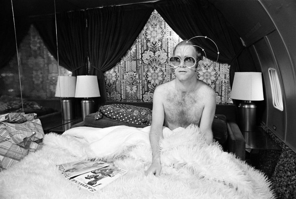 <p>Elton John in bed on board a private jet in 1975. </p>