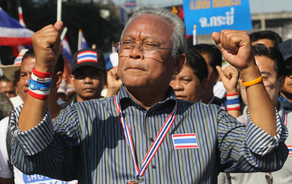 Thai anti-government protest leader Suthep Thaugsuban raises clenched fists during a march with his supporters in Bangkok, Thailand Monday, Jan. 13, 2014. Anti-government protesters took over key intersections in Thailand's capital Monday, halting much of the traffic into Bangkok's central business district as part of a months-long campaign to thwart elections and overthrow the democratically elected prime minister. (AP Photo/Sakchai Lalit)