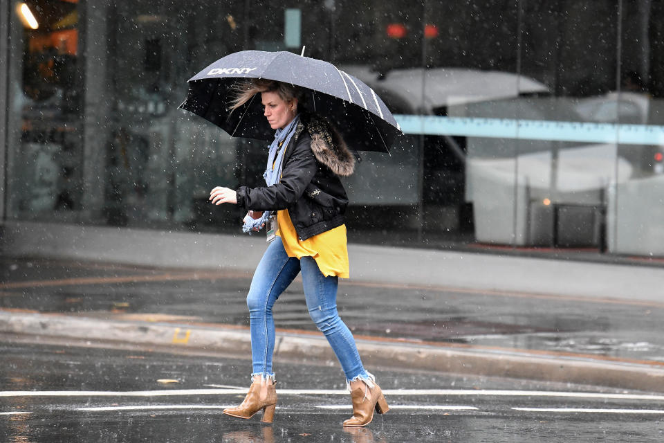 A pedestrian holds an umbrella during wet weather in Parramatta.