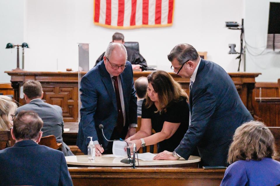 Carrollton school board member Michael Pozderac, left, signs a plea form Thursday during his arraignment before Carroll County Common Pleas Judge Michael V. Repella II.