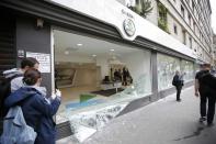 People walk outside an auto dealership which was attacked by youths who took part in a demonstration in protest of the government's proposed labour law reforms in Paris, France, May 26, 2016. REUTERS/Charles Platiau