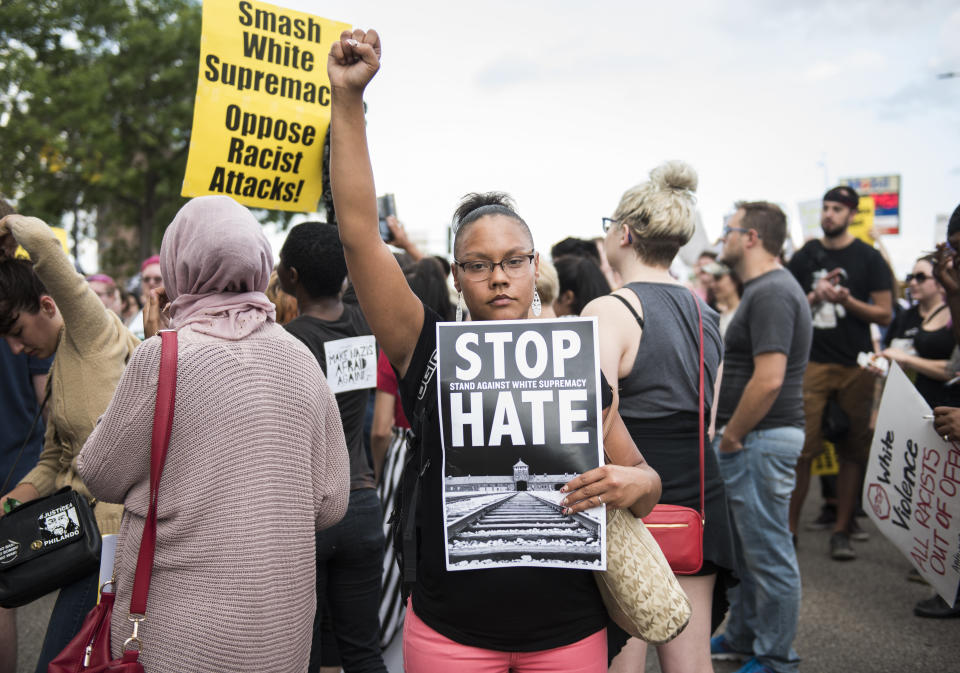 A woman raises her fist at the front of a march down Washington Avenue to protest racism and the violence over the weekend in Charlottesville, Virginia.