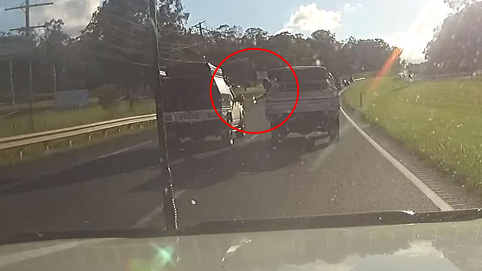 Something, allegedly a beer, was seen passed between two cars on a highway in Queensland. Source: Facebook/Mike Barry