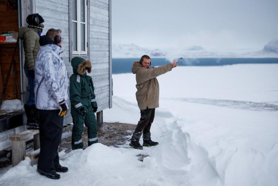 Safety instructor Christer Amundsen demonstrates how to fire a flare gun during training (Reuters)