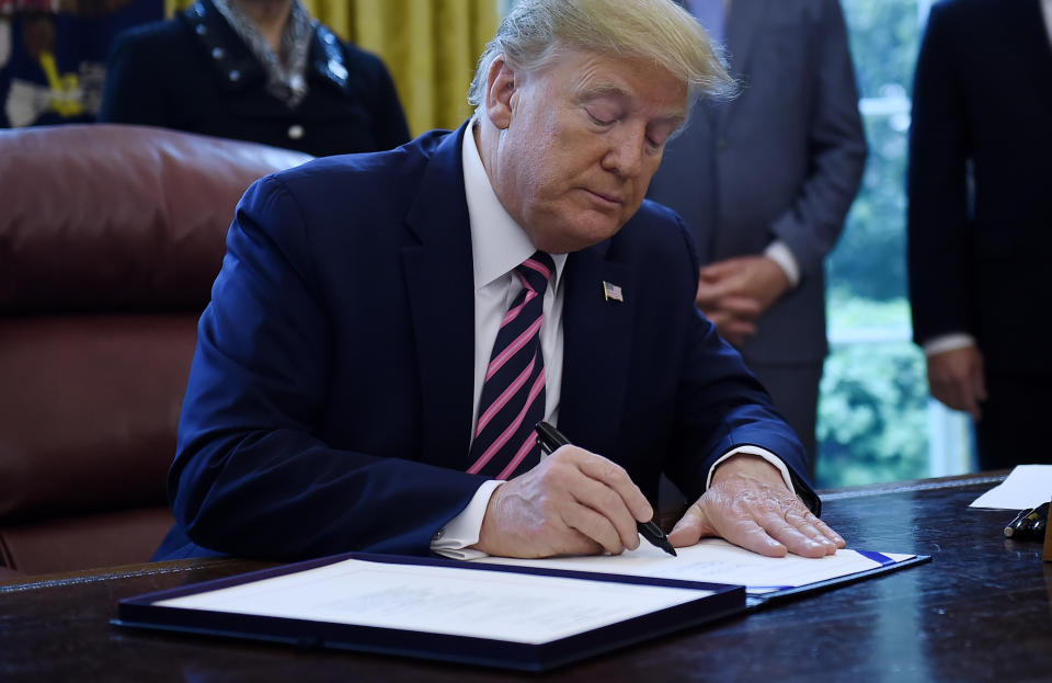 US President Donald Trump signs the Paycheck Protection Program and Health Care Enhancement Act in the Oval Office of the White House in Washington, DC, on April 24, 2020. - The $483 billion stimulus act will back small businesses on the brink of bankruptcy, and allocate more money for health-care providers and virus testing. (Photo by Olivier DOULIERY / AFP) (Photo by OLIVIER DOULIERY/AFP via Getty Images)