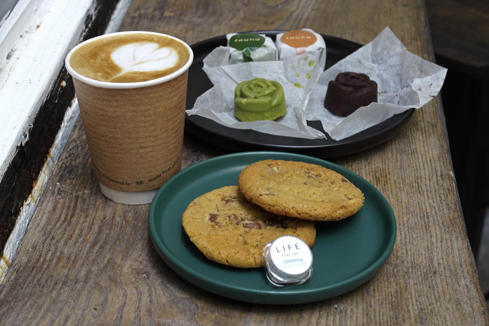 Coffee, biscuits, green tea and chocolate mooncake that contain cannabidiol, or CBD, a substance from the cannabis plant, are displayed at the Found Cafe in Hong Kong on Sept. 13, 2020. Cannabis, also known as marijuana, in Hong Kong may be illegal, but the new Found Cafe is offering a range of food and drinks that contain parts of the cannabis plant without breaking any local laws. (AP Photo/Vincent Yu)