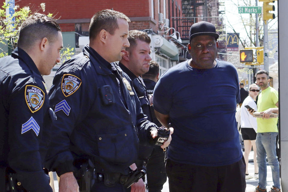 Brooklyn subway shooting suspect Frank James is led away in handcuffs by police in New York's East Village on Wednesday. (AP Photo/Meredith Goldberg)