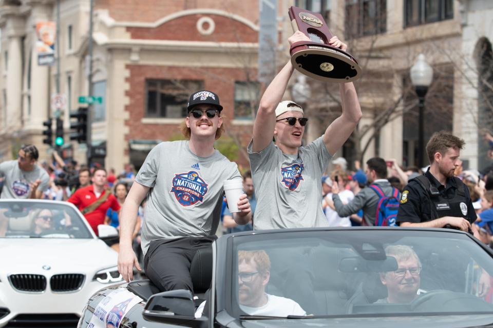 Kansas players Mitch Lightfoot and Chris Teahan show off their NCAA Midwest Regional championship trophy from their ride at Sunday's NCAA Championship parade in downtown Lawrence.