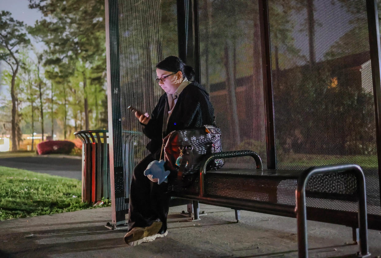 Marshall Shane checks the Chatham Area Transit mobile app to see when the bus will arrive in the early morning hours of Thursday, March 21, 2024. Shane relies on the bus for transportation to and often home from school at Savannah Arts Academy.